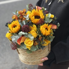 Композиция в сумке "Тональность" из подсолнухов, калл, ягод вибирнума, лимонных роз, скиммии и орхидеи в Дедовске
