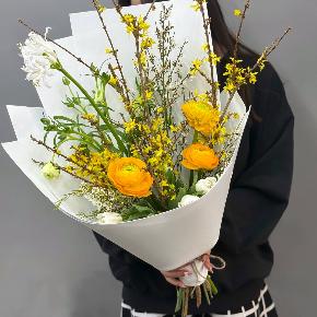Весенний букет с желтыми ранункулюсами и цветущими ветками форзиции в Дедовске